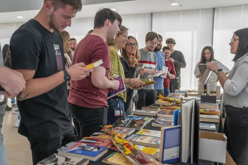 Colaboradores escolhendo livros em uma feira dentro da empresa